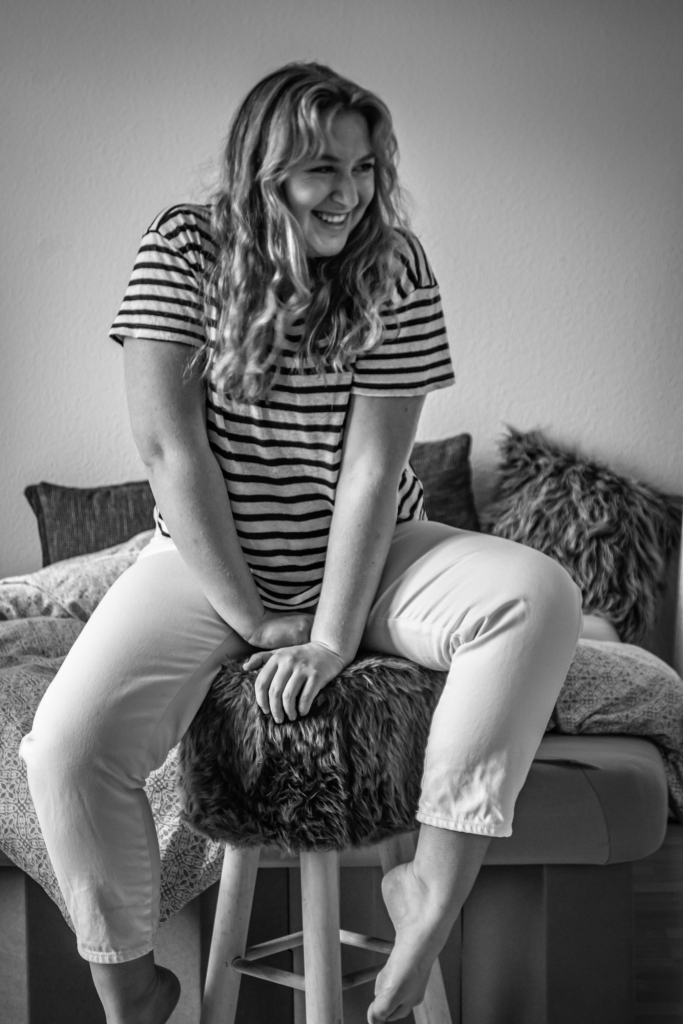 Selbstportrait: ich sitzend auf einem Hocker, Hochformat, schwarz-weiß